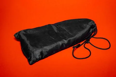 Practical black storage bag on bright orange background for versatile use Stock Photos