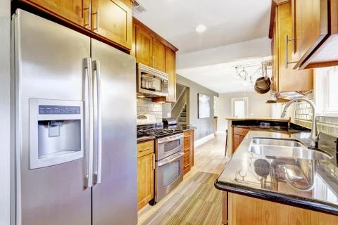 Practical kitchen room interior. Cabinets, steel appliances, granite tops and Stock Photos