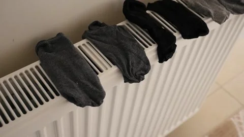 Practical laundry drying at home in winter, socks drying on heating cores, Vídeo Stock 171074491