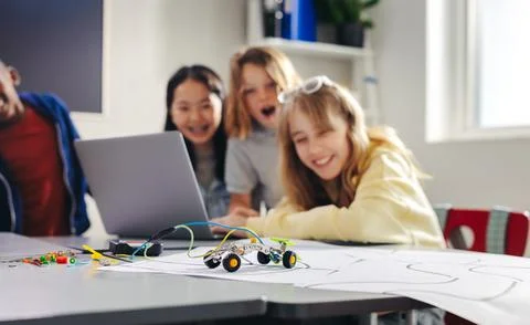 Practical lesson in robot programming: Kids use a computer code to control .. Foto stock