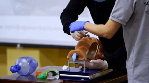 Practical skills for medical students. Instructor helps practitioner Stock Footage 149435176