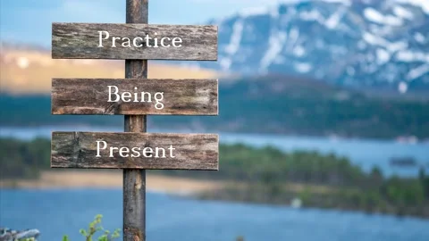 Practice being present text quote on wooden signpost outdoors in nature durin Video stock 170629677