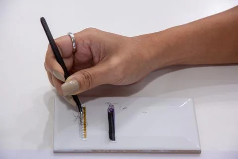 Practice eyelash   extension on tile .Artificial lashes,Work with tweezer, Stock Photos