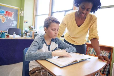 Practice makes progress not perfect. A young teacher assisting a student with Stock Photos