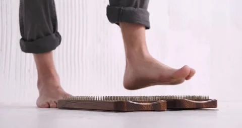 Practice standing on nails concept. The man takes a step on the nails Stock Footage 247472204