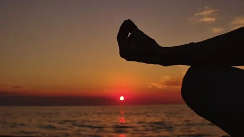 Practice yoga at sunset on a sandy beach by the sea. A woman performs gentle Stock Footage 303693217