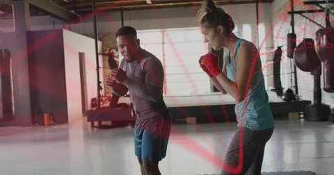 Practicing coach and trainee boxing in loft gym heavy bags, man long-sleeve top, Stock Photos