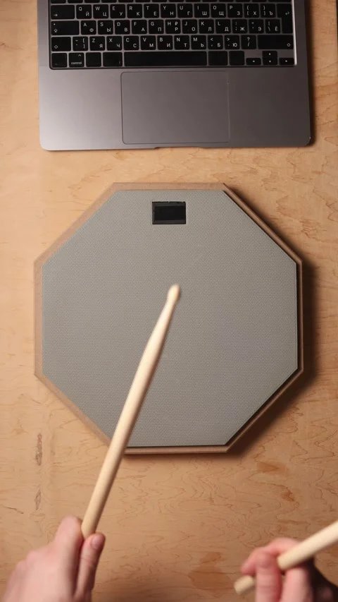 Practicing drumming on a pad with drumsticks and laptop nearby Video stock 341737896
