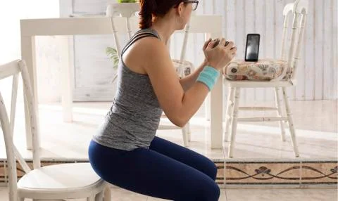 Practicing exercise at home with cell phone Foto stock