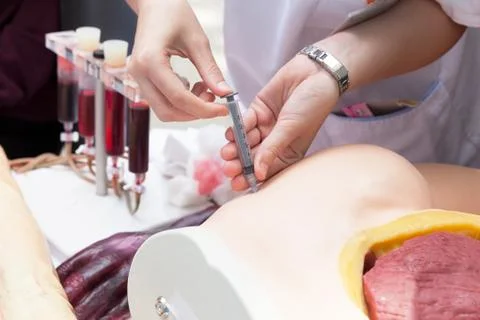 Practicing to give an intramuscular injection Stock Photos