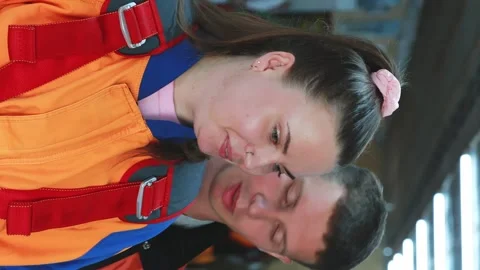 Practicing instructor checks the equipment before the tandem jump, tightens the Stock Footage 250014726