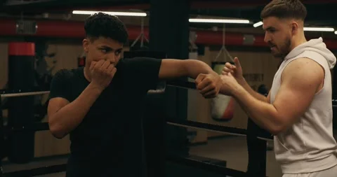 Practicing the punching technique of a boxer under the supervision of a coach. Video stock 275279185