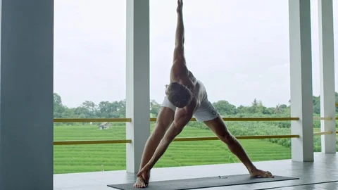 Practicing Revolved Triangle Yoga Pose Stock Footage 92107661