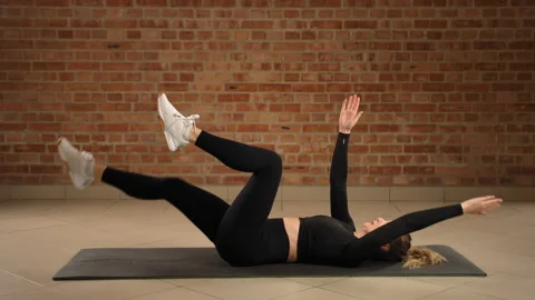 Practicing Right-Sided Dead Bug for Asymmetrical Core Muscle Strengthening Stock Footage 269203105