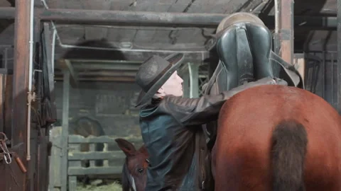 Practicing saddle adjustment and balance checks with cowboy gear. Educational Видео 338715945