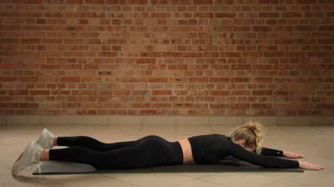 Practicing Superman Exercise for Core Strength and Back Muscle Conditioning Stock Footage 267190527