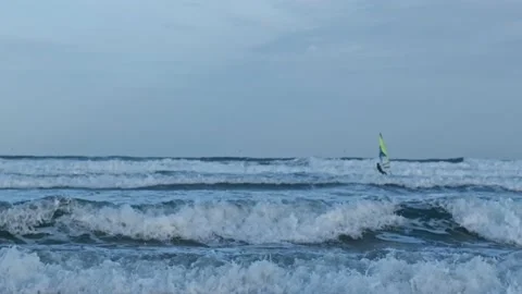 Practicing windsurfing on a beach with a lot of waves and wind 库存影片 232952919