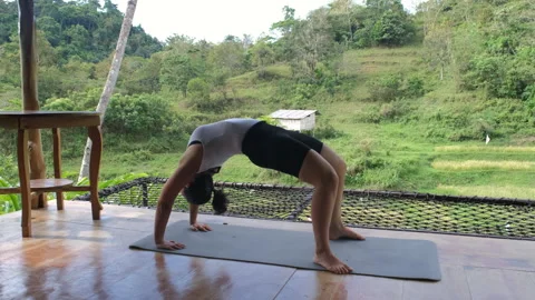 Practicing yoga bridge pose by tropical nature Stock Footage 309270130