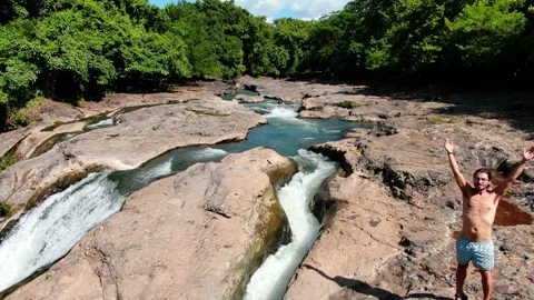 Practicing yoga next to Malacatiupan waterfalls Stock Footage 118680569