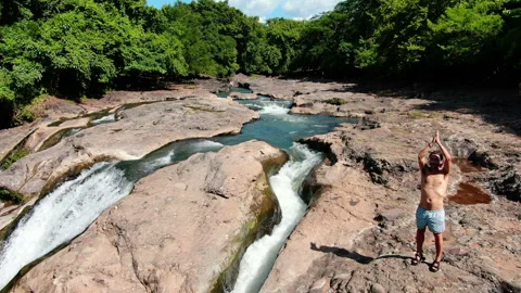 Practicing yoga next to Malacatiupan waterfalls Stock Footage 118684369