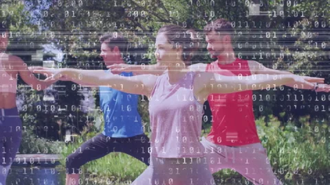 Practicing yoga outdoors, people with binary code animation overlay in park Stock Footage 305286460