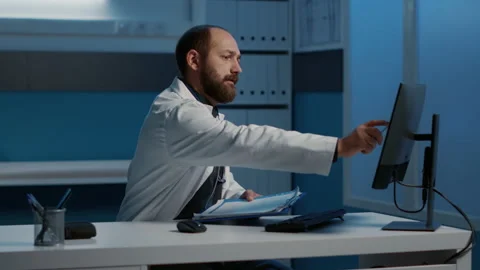 Practitioner doctor checking medical data on computer comparing with expertise Stock Footage 221232214