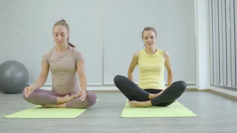 Practitioner doing meditation and exercising healthy lifestyle in fitness studio Stock Footage 146681136