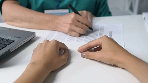 Practitioner marking points in insurance and giving it to patient, healthcare Stock-Footage 119298326