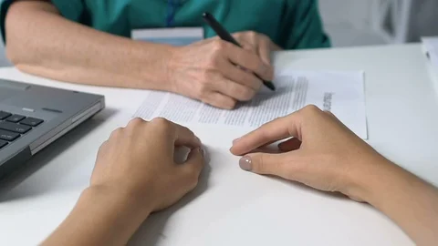 Practitioner marking points in insurance and giving it to patient, healthcare Stock Footage 119298963