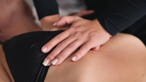 A practitioner performs manual therapy on a person, focusing on the back area to Vídeo Stock 344379674
