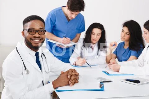 Practitioners And Interns Having Meeting In Medical Office Stock Photos