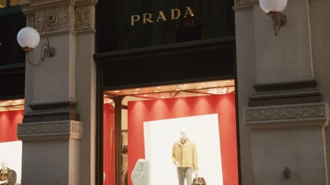 Prada SS26 storefront glows with elegant architecture, golden logo, and vibrant Stock Footage 330033670