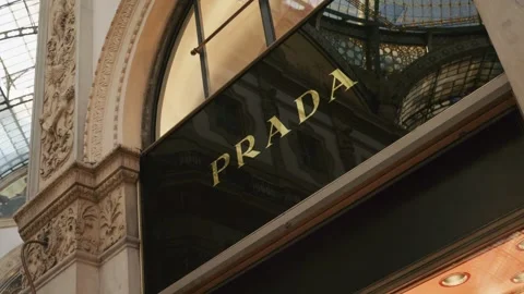 Prada SS26 window display features a chic mannequin in vibrant spring attire, Stock Footage 330033622