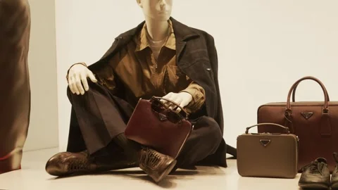 Prada SS26 window display featuring a chic mannequin, elegant coat, and luxury Stock Footage 330033681