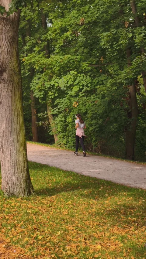 PRAGUE, CZECH REPUBLIC – AUGUST 28, 2026: Woman runs through a green park 4K 스톡 동영상 343923819
