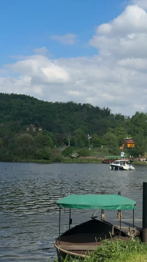 Prague, Czech Republic - May 11, 2026 - white motorboat moves gently across calm Stock Footage 334676448