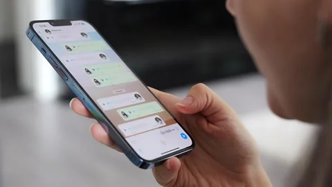 Prague, Czech republic - May 2, 2024: Woman holding iPhone with chat application Stock Footage 274429132