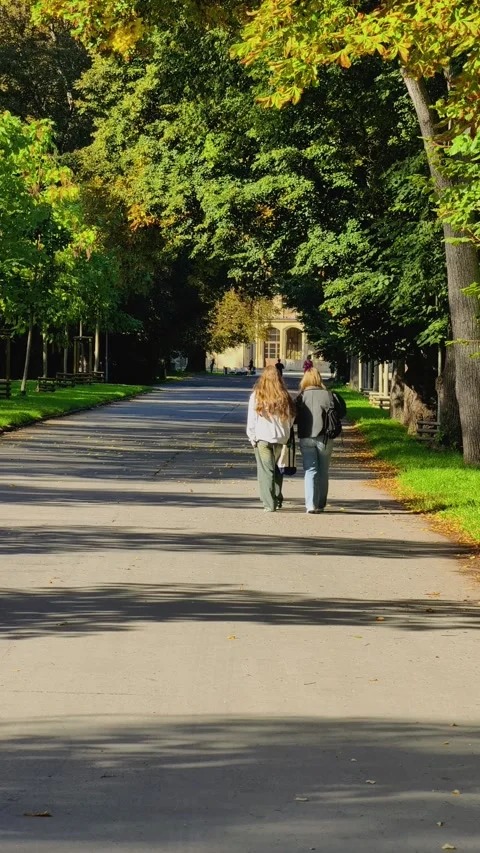 Prague, Czech Republic – September 19, 2026: Two young women walk along a park Stock Footage 345902067