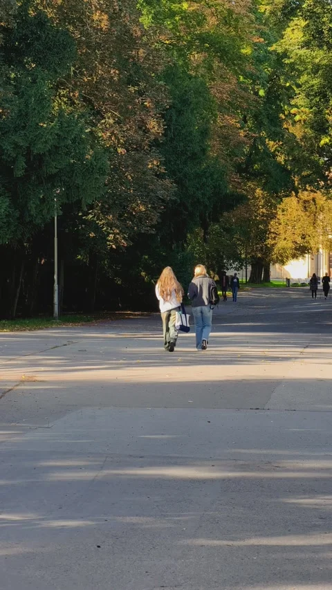 Prague, Czech Republic – September 19, 2026: Two young women walk along a park Stock Footage 345902069