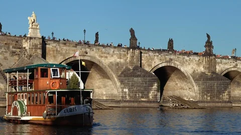 Prague - View of river with Charles Bridge and tourist boat arriving to the pier Stock Footage 95934914