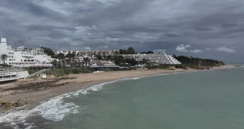 Praia da Oura beach and cliff hotels in Albufeira under stormy sky Stock Footage 346651239