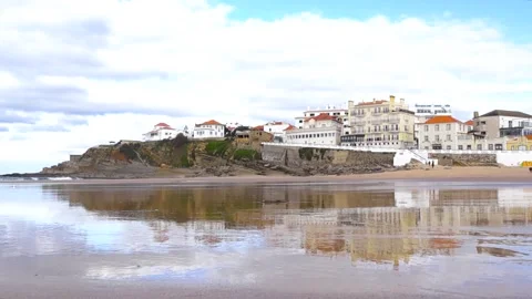 Praia das Maçãs Beach Reflection with Cliffside Town Portugal Stock Footage 331121073