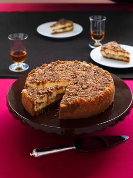 Praline cheese cake on a cake platter with a pie slice Stock Photos