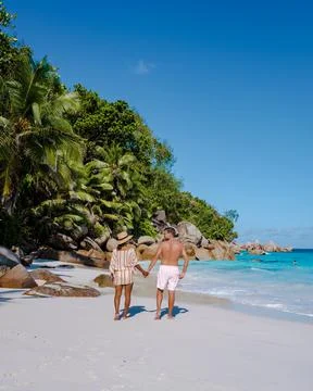 Praslin Seychelles tropical island with withe beaches and palm trees, couple men Stock Photos