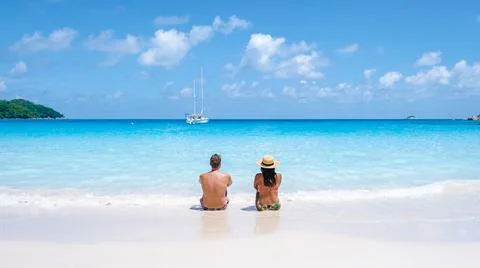 Praslin Seychelles tropical island with withe beaches and palm trees, couple men Stock Photos