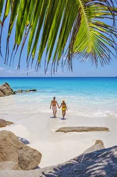 Praslin Seychelles tropical island with withe beaches and palm trees, couple men Stock Photos