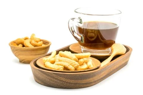 Prawn cracker and a cup of black coffee in a wooden tray with salty cashew .. Stock Photos
