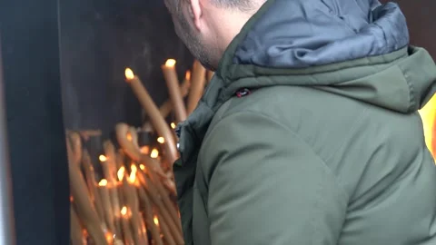 Pray by throwing large candles into the burning fire, Stock Footage 307236840