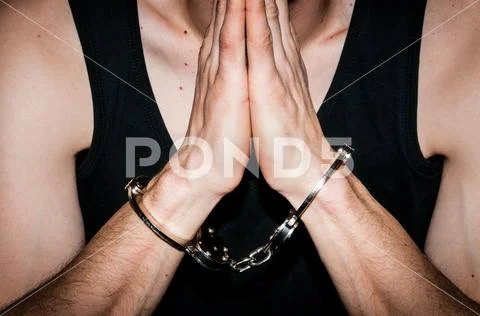 Prayer arrested criminal man with handcuffs on handcuffed hands pray to God Stock Photos