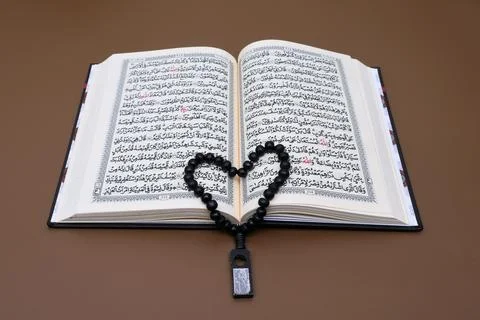 Prayer beads on top of the open Al Quran Stock Photos
